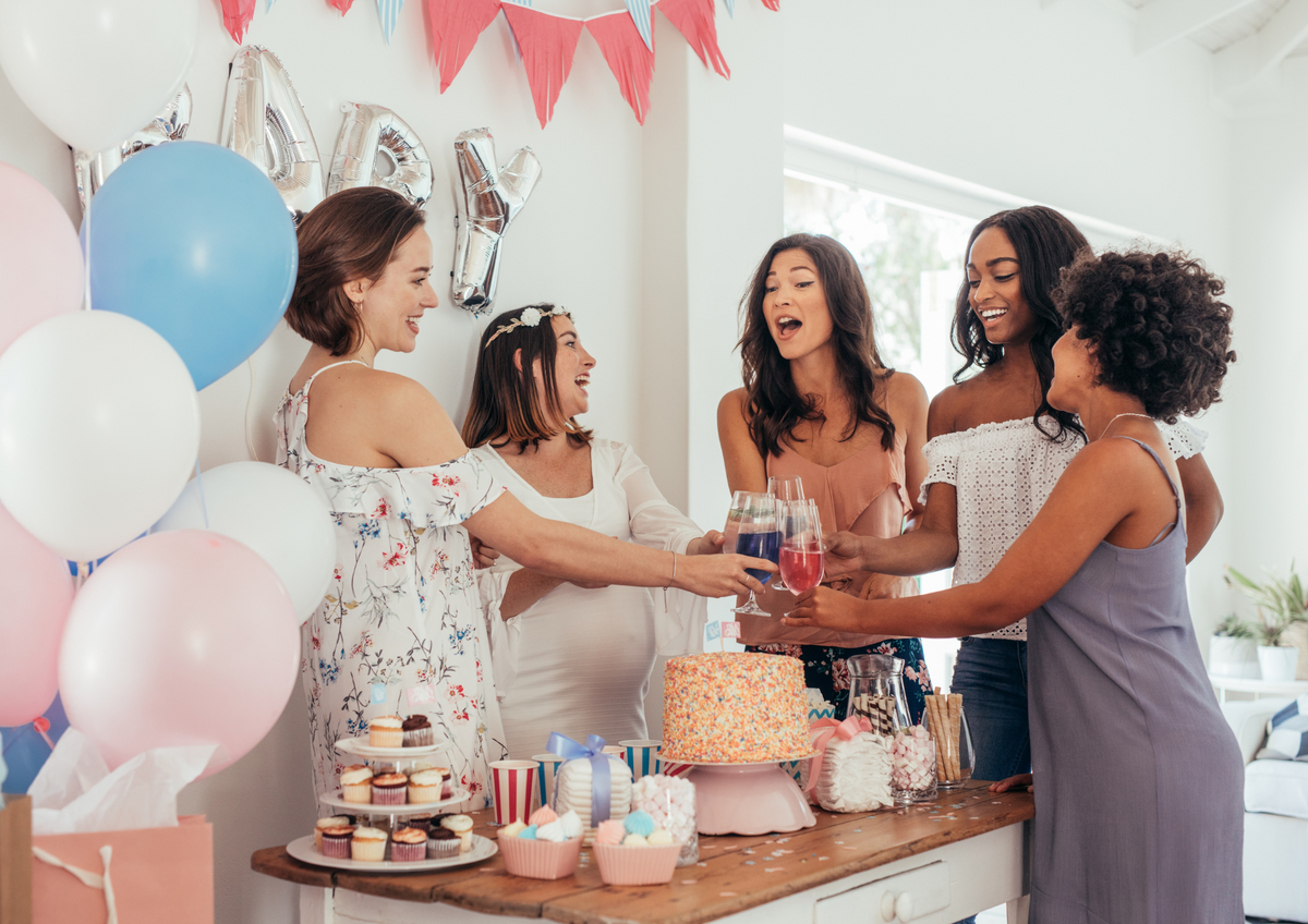 a group of women making a toast at a baby shower party