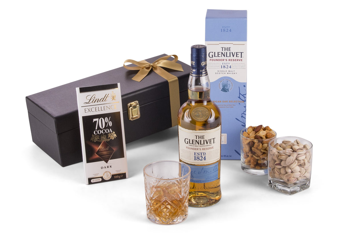 Open bottle of The Glenlivet single malt Scotch whisky in a glass with ice, showcasing the rich amber color.