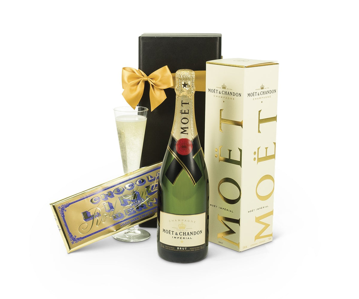 Open bottle of Moet Chandon champagne with a gold foil label, placed on a festive table setting.