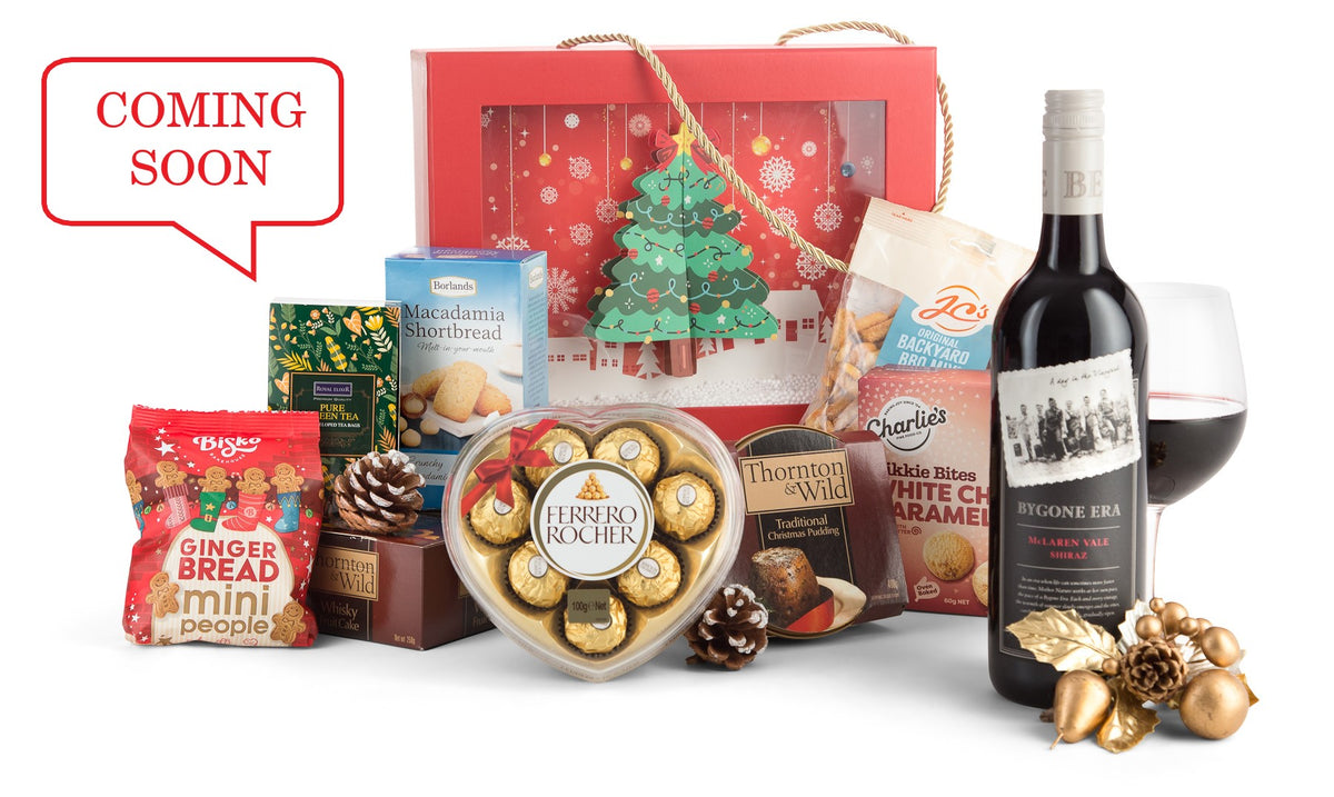 Open red Christmas gift box from Interhampers with festive wrapping and holiday decorations inside.