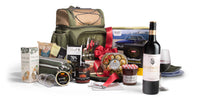 Open picnic basket by Interhampers with plates, utensils, and food items ready for outdoor dining.