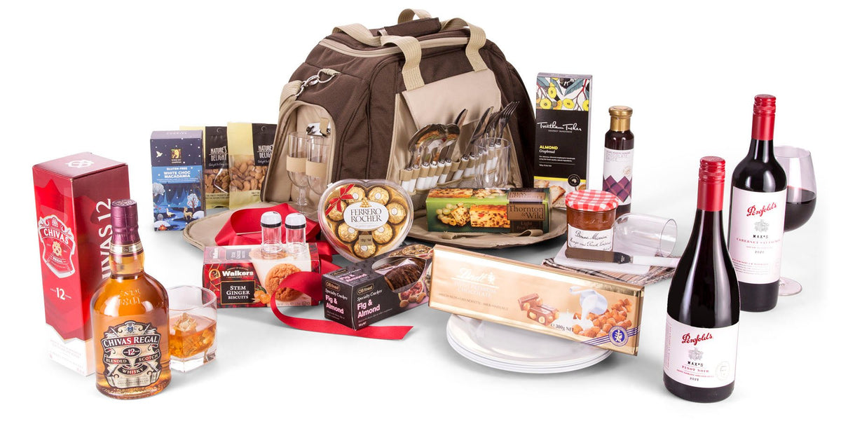 brown picnic bag with cutlery and drinkware in side pockets with hamper contents displayed in front